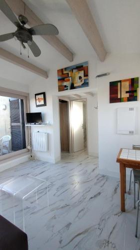 un salon avec un ventilateur de plafond et un sol en marbre dans l'établissement Appartement T2 en résidence Naturiste en bord de Mer, à Leucate-Plage