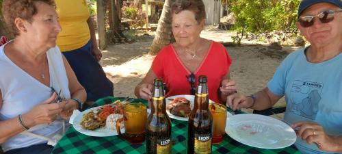 a group of people sitting at a table with food and drinks at Sun Sea Family House Tangalle in Tangalle