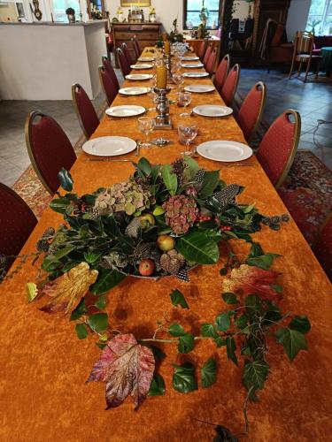 a long table with leaves and flowers on it at Skelstrupgaard Apartments in Maribo