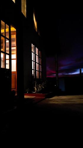 a building with windows at night with the light coming in at The Mount Lodge in Nuwara Eliya