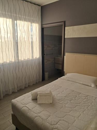 a bedroom with a large bed and a large window at Hotel Palace Gioia Tauro in Gioia Tauro