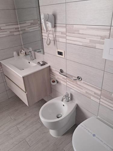 a white bathroom with a toilet and a sink at Hotel Palace Gioia Tauro in Gioia Tauro