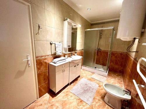 a bathroom with a shower and a sink and a toilet at Belien Apartman in Makó
