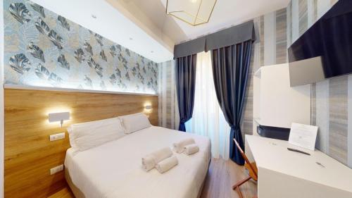 a bedroom with a white bed and a desk at ROME'S GLORIA HOTEL in Rome