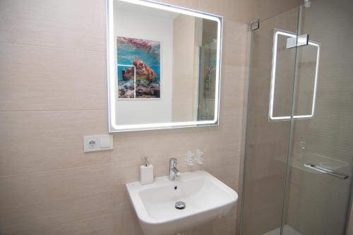 a bathroom with a sink and a mirror and a shower at Casa PLAYA FONTANILLA in Conil de la Frontera