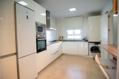 a kitchen with white cabinets and a counter top at Casa PLAYA FONTANILLA in Conil de la Frontera