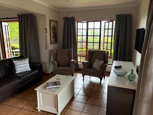a living room with a couch and chairs and a table at The Gem Emerald in Graskop