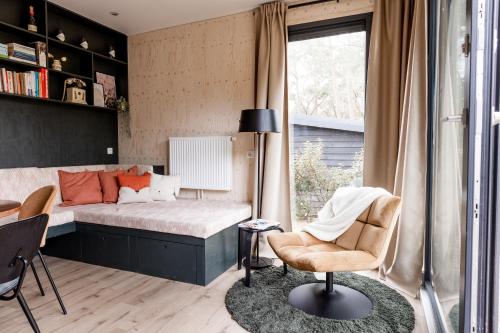 ヌンスペートにあるUltiem ontspannen in luxe en design ingericht tiny house in bosrijke omgevingのベッドと机と椅子のある寝室