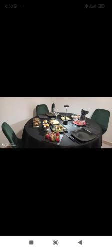 a black table with green chairs and food on it at RUDIAE Palace In Lecce in Lecce