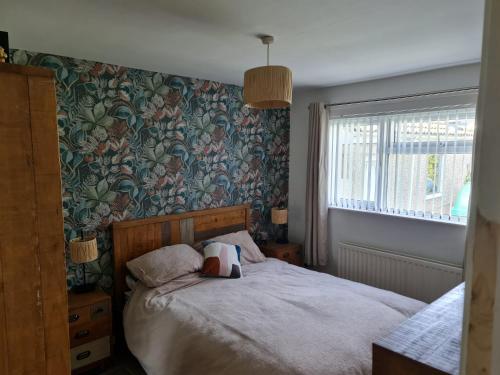 a bedroom with a bed with a flowery wallpaper at Mourne Mountains holiday home in Newcastle