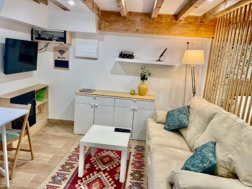 a living room with a couch and a table at Studio COZY avec jardin au centre ville d'Hendaye à 10 minutes d'Espagne in Hendaye