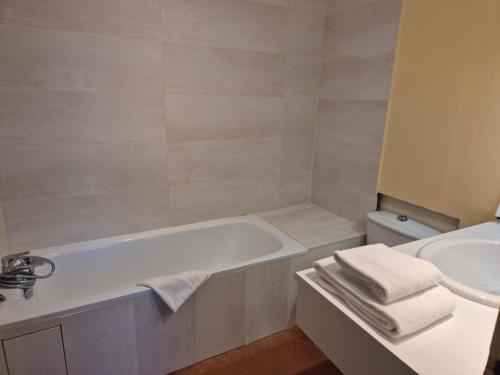 a bathroom with a bath tub and a sink at Hotel Saint Jean in Chalon-sur-Saône