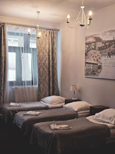 a room with three beds and a window at Zamek Międzylesie in Międzylesie