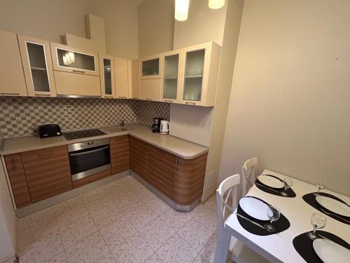 a kitchen with white cabinets and a table and chairs at OLD TOWN Republika - 2 rooms - Self Check In - 24 hours - Free parking in Liepāja