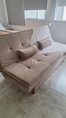 a brown couch with pillows on it in a room at Apartamento 2 en el Centro de Chuy - Inmejorable Localización in Chuy