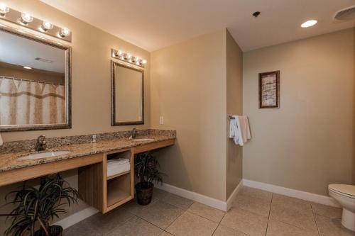 Un baño con lavabo, inodoro y espejo. en Splash Ocean-front Luxury Two-bedroom Beach Condo, en Panama City Beach