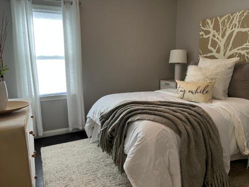 a bedroom with a bed with a blanket and a window at Cozy, 1st floor apartment 2bdrms Plus Semi Private room with Futon Pets with fee Family Friendly Close to Everything in Cleveland