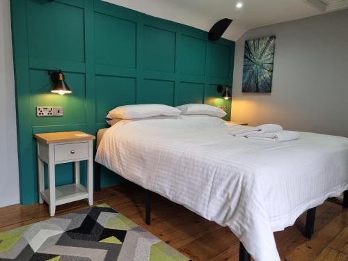 a bedroom with a large bed and a green wall at Old Manor House in Axbridge