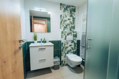 a bathroom with a white sink and a toilet at Apartmány J&J in Šumperk