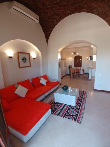 a living room with a red couch and a table at Rihana 2 bedrooms in Hurghada