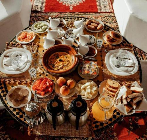 a table with plates of food on a table at Merzouga Sahara Desert Camp in Merzouga