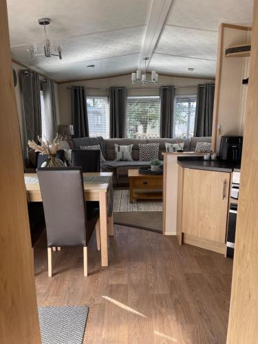 a kitchen and living room with a table and a couch at 5 the green,lilliardsedge holiday park in Harrietsfield