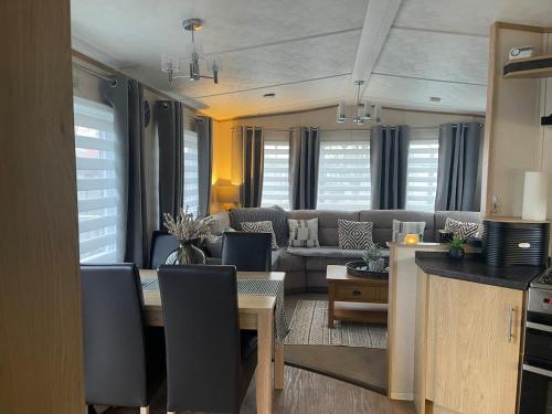 a living room with a table and a couch at 5 the green,lilliardsedge holiday park in Harrietsfield