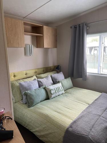 a bedroom with a bed with pillows on it at 5 the green,lilliardsedge holiday park in Harrietsfield