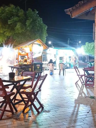 a group of tables and chairs on a patio at night at Cantinho do sossego in Trairi