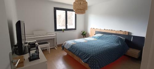 une chambre avec un lit, un bureau et une télévision dans l'établissement Villa au calme avec piscine et jacuzzi, à Saint-Vincent-de-Mercuze