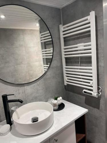 une salle de bain avec un lavabo blanc et un miroir dans l'établissement Maisonnette Le Galet Jaune, à Bretignolles-sur-Mer