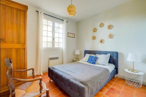 une chambre avec un lit, une chaise et une fenêtre dans l'établissement Maison La Pinède authentique & familiale Vue Mer, à Ensuès-la-Redonne