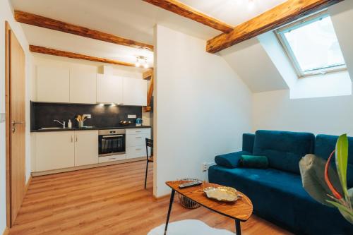 a living room with a blue couch and a table at Apartmány J&J in Šumperk