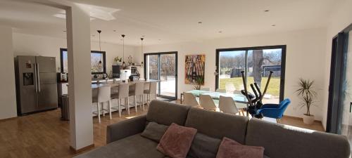 un salon et une cuisine avec un canapé et une table dans l'établissement Villa au calme avec piscine et jacuzzi, à Saint-Vincent-de-Mercuze