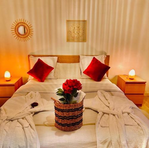 a bedroom with a bed with a basket of flowers on it at Grande maison romantique avec jacuzzi intérieur & parking, à 1h30 de Paris in Montbouy