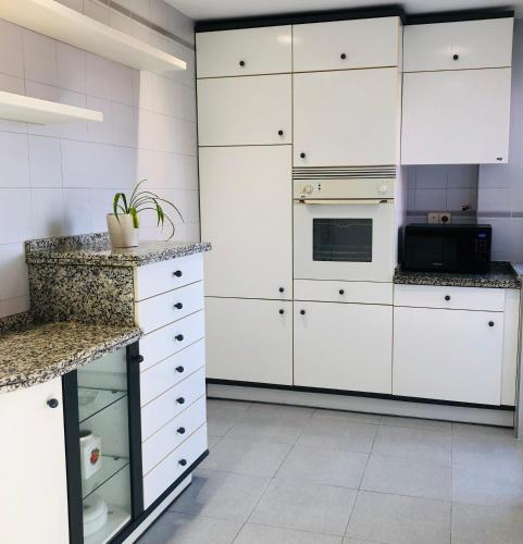 a kitchen with white cabinets and a counter top at Piso céntrico y luminoso in León