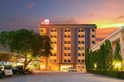 a hotel building with a neon sign on top of it at BaanHim in Rayong