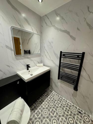 a white bathroom with a sink and a mirror at 267 Stylish 2 Bed Apartment City Centre Free Parking in Cardiff
