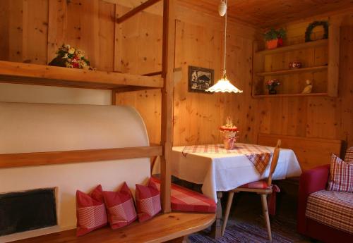 a room with a table and a bunk bed at Apartments Mauriz in Selva di Val Gardena