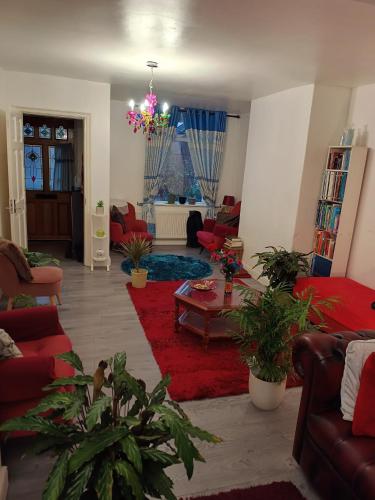 a living room with red furniture and a red rug at High Street House WEST BROMWICH in West Bromwich