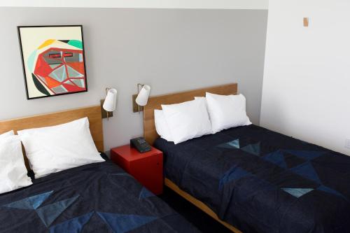a bedroom with two beds and a painting on the wall at The Durham Hotel in Durham