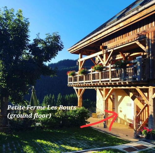 une photo d'une maison avec un balcon et une flèche rouge dans l'établissement Family stays in Petite Ferme Les Bouts & Grenier Les Bouts - 2 properties side by side, à La Côte dʼArbroz