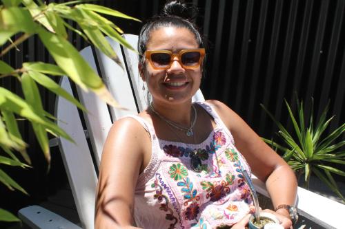 a woman wearing sunglasses and smiling at the camera at Compay Hostel Punta del Diablo in Punta Del Diablo