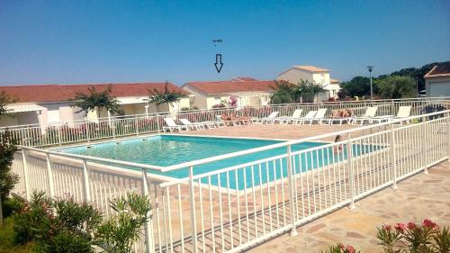 une piscine entourée d'une clôture blanche. dans l'établissement Villa bord de mer,3 chambres, piscine chauffée, climatisée, à Cervione