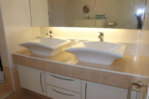 - une salle de bains avec 2 lavabos blancs sur un comptoir dans l'établissement La maison du théâtre, à Sanary-sur-Mer