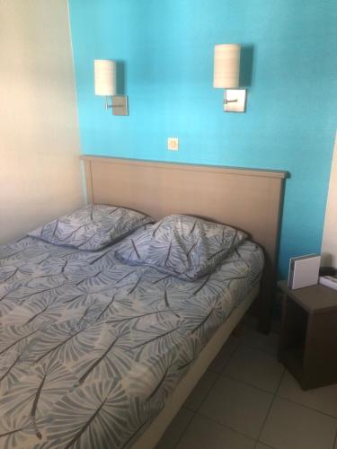 Ce lit se trouve dans un dortoir doté de 2 lumières sur le mur. dans l'établissement pierre et vacances, à Cannes