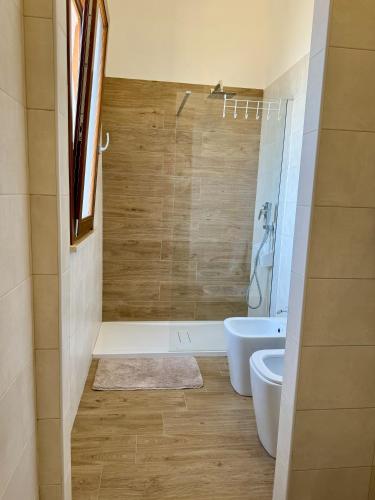 a bathroom with a tub and a toilet and a sink at Aria case vacanze in Favignana