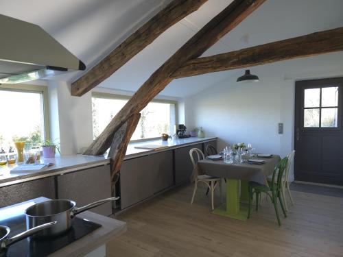 une cuisine avec une table et des chaises dans une pièce dans l'établissement Fleur de Champagne - Gîte Garden, à Saudoy