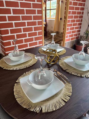a wooden table with plates and bowls and wine glasses at Sacred Garden Home in Cusco