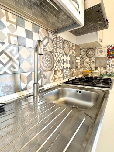 a kitchen with a sink and a stove at Aria case vacanze in Favignana